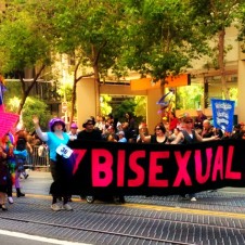 Parade participants carrying a large bisexuals banner