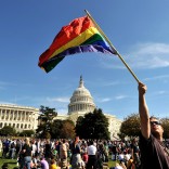 Protestor with Pride flag in front of US Capitol