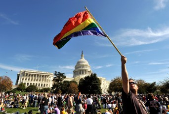 Protestor with Pride flag in front of US Capitol