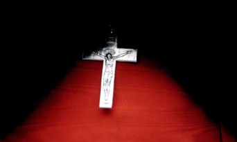 Small cross on wooden background