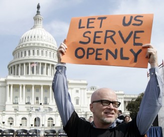 Protester holds "Let us serve openly" sign near US Capitol building