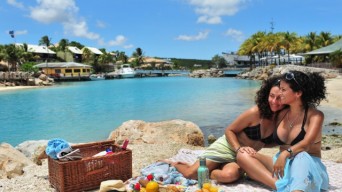 Two women by ocean with picnic