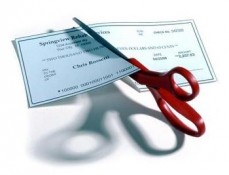 Scissors cutting paycheck