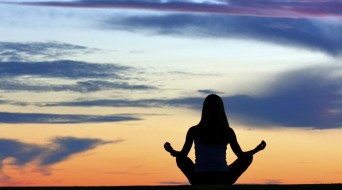Woman doing yoga at sunrise