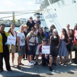 Sweet travelers posing beside a ship