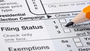 Pencil checking married on tax form