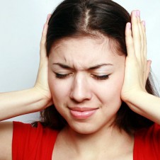 woman covering her ears