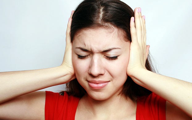 woman covering her ears