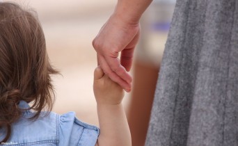 Woman holding child's hand