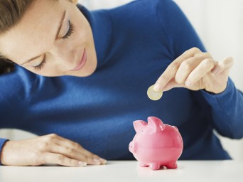 woman-putting-money-into-a-piggy-bank