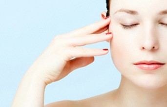 Woman with hand on head and eyes closed
