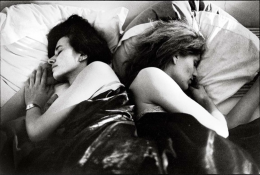 Women in bed with their backs to each other