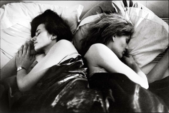 Women in bed with their backs to each other
